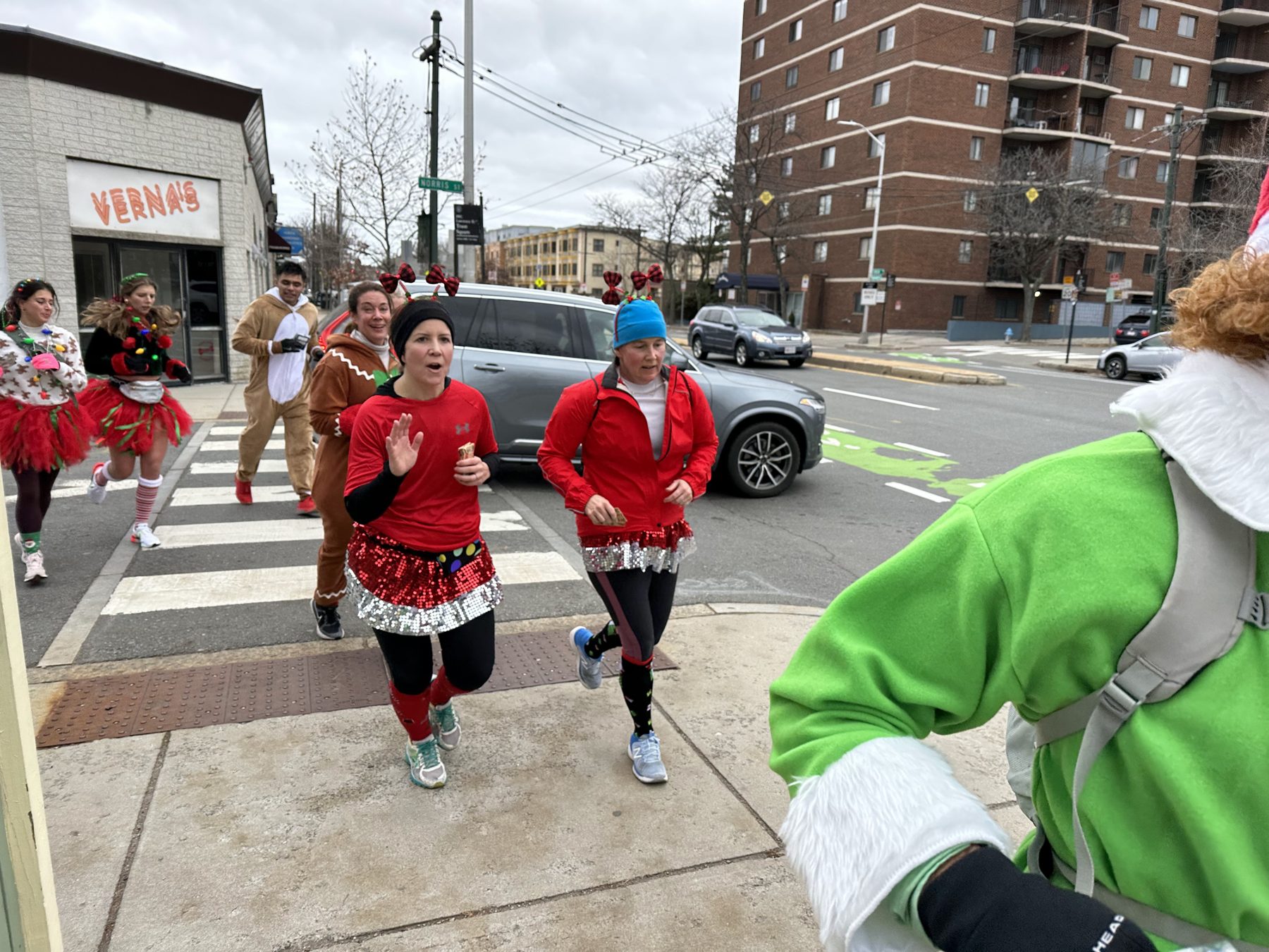 Gallopers in sequined skirts and costumes crossing Mass Ave with gift cards